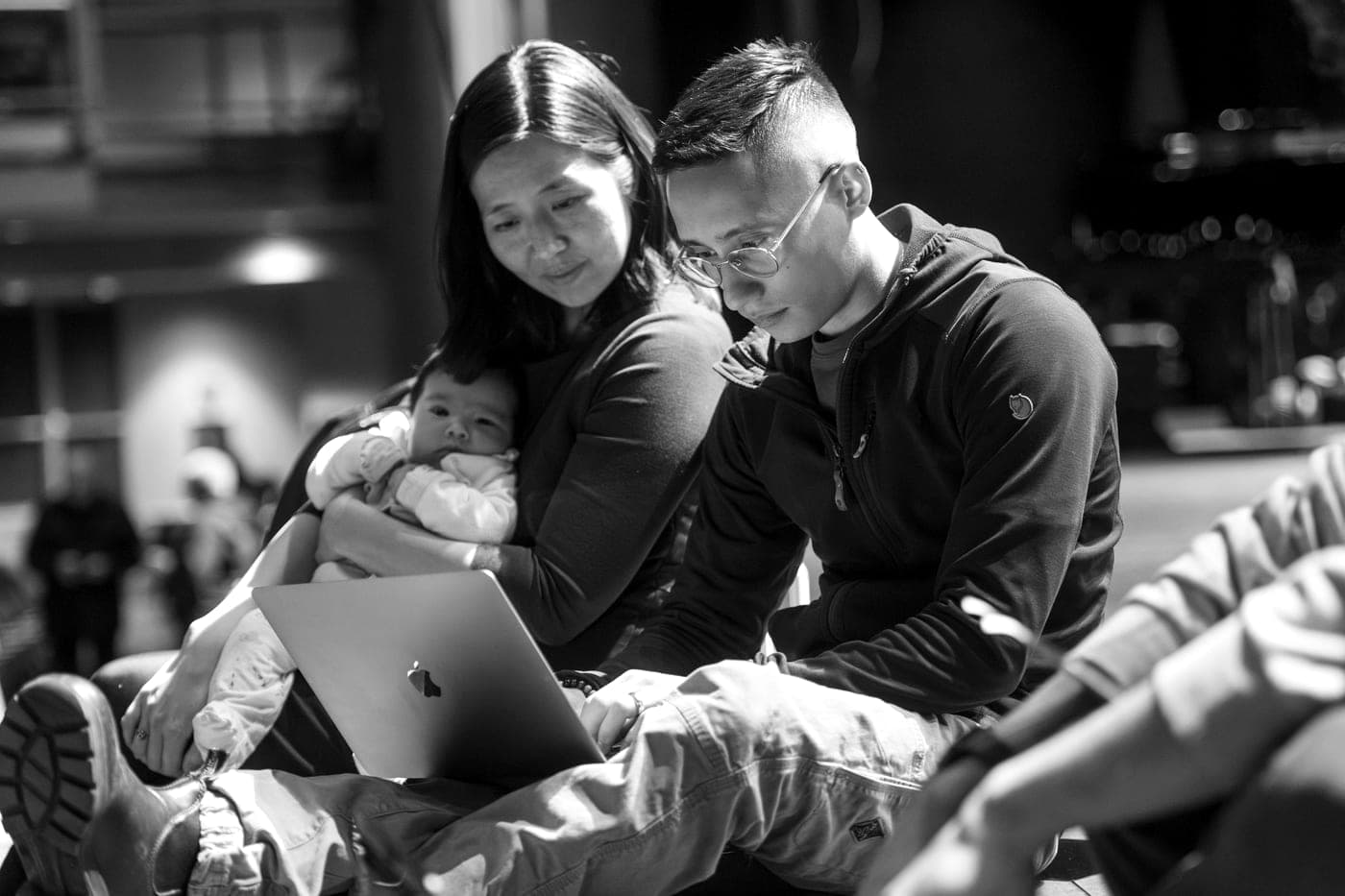 Ezra Zwaeli and Mayor Michelle Wu reviewing a draft on a laptop, the Mayor holding her infant